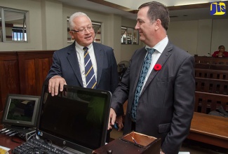 In this file photo, Justice Minister, Hon. Delroy Chuck (left), and Canadian High Commissioner to Jamaica, His Excellency Sylvain Fabí, discuss some of the features of one of the newly designated courtrooms for criminal case trials at the Supreme Court in downtown Kingston, during a tour of the facility on November 1 last year. 