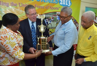 Minister with responsibility for Sports, Hon. Natalie Neita-Headley (left), along with Canadian High Commissioner to Jamaica, His Excellency Robert Ready (2nd left); Chief Executive Officer, Council of Voluntary Social Services (CVSS), Winsome Wilkins (2nd right); and LIME Foundation Chairman, Errol Miller, view the championship trophy, one of several prizes up for grabs at this year’s renewal of the CVSS Summer Games, during the event’s launch at the National Volunteer Centre, Camp Road, Kingston, on Thursday, June 20.