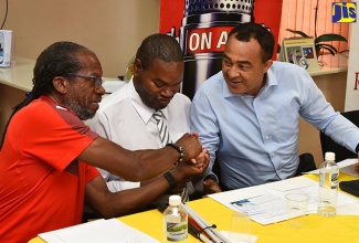 Health Minister, Dr. the Hon. Christopher Tufton (right), shakes the hand of Director of Running Events Limited, Alfred Francis (left), during the media launch of the ‘Everyone’s a Winner’ 5k and 10k race on Tuesday (April 10) at the Jamaica Society for the Blind (JSB) headquarters on Old Hope Road in Kingston.  At centre is Chairman of the JSB, Daemion McLean. Proceeds from the event, to be held on April 29, will be used to purchase computers for a lab at the JSB.