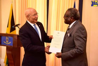 Governor-General, His Excellency the Most Hon. Sir. Patrick Allen (left), presents incoming Custos of St. James, Bishop the Hon. Conrad Pitkin, with his instrument of appointment during his swearing-in ceremony at King’s House, on Monday (January 29).