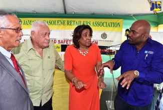 Science, Energy and Technology Minister, Dr. the Hon. Andrew Wheatley (right), makes a point to Executive Director of the National Road Safety Council (NRSC), Paula Fletcher (second right), at the Jamaica Gasolene Retailers Association Annual Launch of Road Safety Month, at the Molynes Road Texaco Station in St. Andrew, on June 7. Others (from left) are JGRA President, Phillip Chong, and Transport and Mining Minister, Hon. Mike Henry.