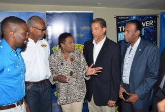 Culture, Gender, Entertainment and Sport Minister, Hon. Olivia Grange (centre) raises a point with Director of Corporate Services at Sandals Resort International, Jeremy Jones (second right), at the launch of the Sandals Under 19 Cricket Competition and Academy Programme, at Sabina Park in Kingston, on April 21. Looking on (from left) are Sponsorship & Events Manager at WISYNCO, Jermaine Brown, General Manager of Rainforest Seafoods, Jerome Miles and President of the Jamaica Cricket Association, Wilford Heaven.
Cricket 2: Culture, Gender, Entertainment and Sport Minister, Hon. Olivia Grange (right) is in discussion with Director of Corporate Services at Sandals Resort International, Jeremy Jones (left) at the launch of the Sandals Under 19 Cricket Competition and Academy Programme, at Sabina Park in Kingston, on April 21. Looking on at (centre) is Jamaican Under-15 team representative, Razaq Williams. 