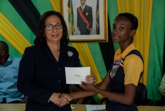 Minister of Labour and Social Security, Hon. Shahine Robinson (right), presents a cheque to student at Marcus Garvey High, Sashel Morris, during a grant presentation ceremony at the Ministry’s offices at 1F North Street in Kingston, on April 29. The grants, which totalled $500,000, were presented to 10 students from various high schools in St. Ann. The money was raised through fund-raising efforts of workers employed to Gebbers Farms in Washington, United States.