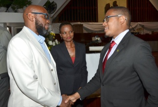 Education, Youth and Information State Minister, Hon. Floyd Green (right), is greeted by  Pastor of Webster Memorial United Church in St. Andrew, Rev. Astor Carlyle, during the Church’s child abuse forum on May 11. Looking on is the forum’s moderator, Shawn Wilkinson. 