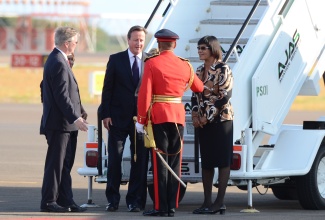 Prime Minister, the Most Hon. Portia Simpson Miller (right), looks on as Chief of Defence Staff, Major General Antony Anderson  is introduced to Prime Minister of the United Kingdom (UK), the Rt. Hon. David Cameron (third right), by  British High Commissioner to Jamaica, His Excellency David Fitton (left). Prime Minister Cameron arrived at the Norman Manley International Airport in Kingston, today (September 29) for a two-day official visit.