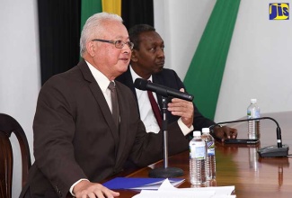 Justice Minister, Hon. Delroy Chuck (left), speaks at a recent contract-signing ceremony for the commencement of work to expand the Public West Building in downtown Kingston, which houses the Court of Appeal and the Office of the Director of Public Prosecutions. The ceremony was held at the Ministry on Constant Spring Road in St. Andrew.  Seated at right is President of the Court of Appeal, Justice Dennis Morrison.