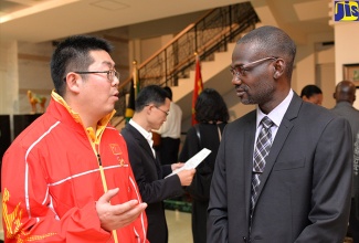 Newly appointed Permanent Secretary of the Ministry of Culture, Gender, Entertainment and Sport, Denzil Thorpe (right), in discussion with Team Leader, Jiang Lin (left), at a welcome reception for visiting Chinese coaches  at  the Chinese Ambassador’s residence in Kingston on January 11. Mr. Lin and other coaches arrived in Jamaica on January 11 for a 30-day training programme with local coaches and athletes in seven disciplines.