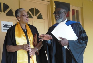 Academic Dean at the All American Institute of Medical Sciences in Black River, St. Elizabeth, Dr. Sheila Campbell Forrester (left), in discussion with Chairman of the Board,  Dr. Simon Clarke (right),  at the institution’s inaugural graduation exercise on December 4.