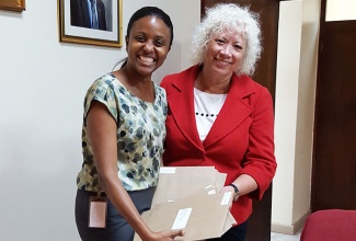 Chairman of the Early Childhood Commission (ECC), Trisha Williams-Singh (left), accepts cheques valued at $4.5 million from Board Director, the Project For The Advancement of Childhood Education (PACE) Canada, Ms. Diana Burke, in November 2016.