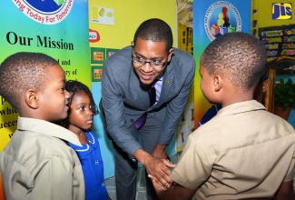 In this file photo, State Minister in the Education, Youth and Information Ministry, Hon. Floyd Green (third left), interacts with (from left): Dammi Hannigan, Dominique Parkes and Drew Stewart of the St. Margaret’s Basic School in Portland on January 26. Occasion was a ceremony organised by the Early Childhood Commission (ECC) to announce the certification of the school.
	
