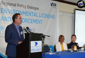 Minister without Portfolio in the Ministry of Economic Growth and Job Creation, Hon. Daryl Vaz (at podium), speaks at the opening session for a Caribbean Regional Policy Dialogue on Environmental Licensing and Compliance conference at The Jamaica Pegasus hotel, on July 27.   Seated (from left) are General Manager, Caribbean Country Department, Inter-American Development Bank (IDB), Therese Turner-Jones; and Chief, Environmental Safeguards Unit, IDB, Janine Ferrett