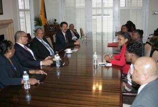 Minister of Finance and Planning, Dr. the Hon. Peter Phillips (third left), addresses staff members  of the embassy of Jamaica in Washington, D.C.,  on October 11.  To the Minister’s right is Governor of the Bank of Jamaica (BOJ), Brian Wynter  and to his left is Ambassador to the United States, His Excellency Stephen Vasciannie.