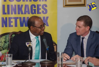 Minister of Tourism, Hon. Edmund Bartlett, expresses his confidence in the Chairman, Tourism Linkages Council, Adam Stewart, during the meeting of the council at the Ministry's New Kingston offices on June 23.