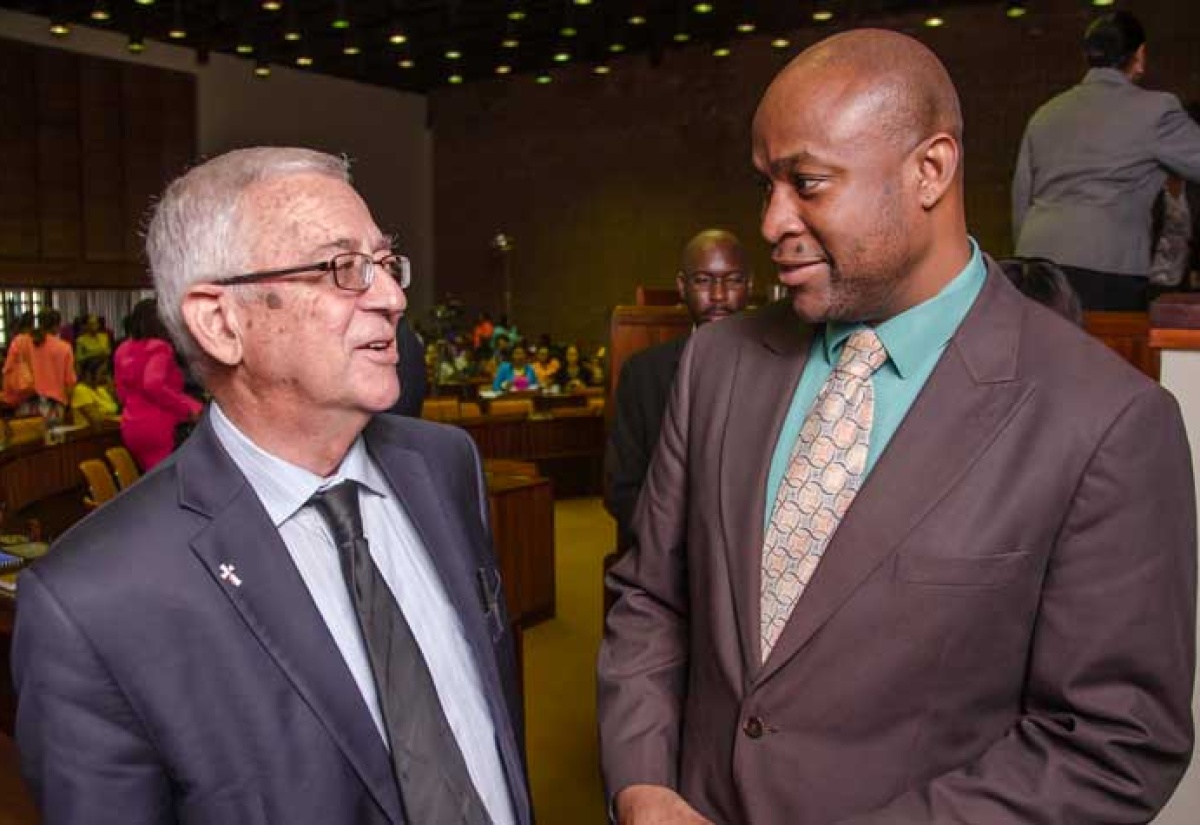 Minister of Education, Hon. Rev. Ronald Thwaites (left), in conversation with Permanent Secretary in the Ministry, Dr. Maurice Smith, following a meeting to sensitise and prepare staff for the development of the Department of School Services (DSS), held at the Jamaica Conference Centre, on  December 11.