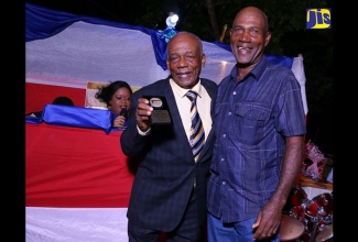 Fitz Albert Brown (left), one of  22 persons honoured at the Cherry Community Youth Society’s second annual awards dinner, receives his plaque from one of his employees, Clarence Facey. Mr. Brown has been a house builder for 58 years. The event was held on January 1 in the West Central St. Catherine community.