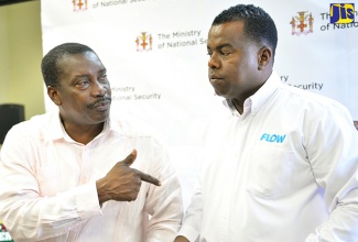 Minister of National Security, Hon. Robert Montague (right), is in discussion with Head, Product Support, Flow, Troy Cockings, during a press conference at the Ministry’s Oxford Road offices in Kingston today (Jan. 26). The Ministry of National Security has partnered with telecommunications companies Digicel and Flow to make the ‘Stay Alert’ application automatically available on smartphones.