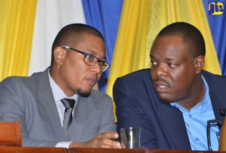 Minister of State in the Ministry of Education, Youth and Information, Hon. Floyd Green (left), in discussion with Executive Director of HEART Trust/NTA, Dr. Wayne Wesley, while at a symposium and awards ceremony organized by the agency, for Community Training Interventions trainers and coordinators, held on Friday (November 4), at the Jamaica Conference Centre, in Downtown, Kingston.