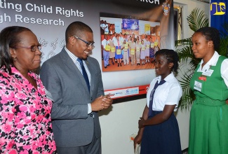 State Minister in the Education, Youth and Information Ministry, Hon. Floyd Green (2nd left), speaks with Grove Town Primary School student Shakelia Knight (centre); and Office of the Children’s Registry Child Ambassador, Denae Edwards (right) at the Caribbean Child Research Conference held recently, at the Golf View Hotel in Mandeville. At left is Conference Chair and Acting Director of the Sir Arthur Lewis Institute of Social and Economic Studies (SALISES), Dr. Aldrie Henry-Lee. 