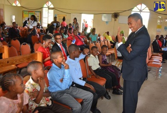 Minister of State in the Ministry of Education, Youth and Information, Hon. Floyd Green (right), interacts with children from St. Christopher School for the Deaf, during the church service to launch National Youth Month (November),  at the Steer Town New Testament Church of God, in St. Ann., on  Sunday, October 30. The Month will be observed under the theme: ‘Energizing Youth’ .