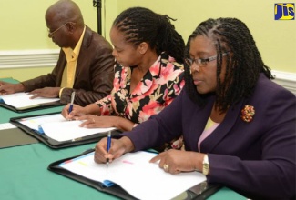 President and Chairman of Spatial Innovision Ltd., Mr. Silburn Clarke (left), Assistant Chief Education Officer in the Educational Planning Unit of the Ministry of Education, Youth and Information, Dasmine Kennedy (centre) and Permanent Secretary in the Ministry of Economic Growth and Job Creation, Mrs. Audrey Sewell, sign a Memorandum of Understanding for the management of geographical information systems (GIS) technology in 57 secondary and tertiary schools, during a ceremony at the Knutsford Court Hotel in Kingston on May 4. (File image)