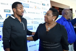 Minister of Culture, Gender, Entertainment and Sport, Hon. Olivia Grange (right), speaking with Jamaican sprinter Yohan Blake during the press launch of the 2018  Jamaica National (JN) Racers Grand Prix on Thursday, April 19 at The Jamaica Pegasus hotel in Kingston. The meet is slated to be held on Saturday, June 9 at the National Stadium in Kingston. 