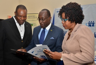 Minister of Education, Youth and Information, Senator the Hon. Ruel Reid (centre), checks a document along with Executive Director of HEART Trust/NTA, Dr. Wayne Wesley (left) and Chairman, Ms. Maxine Wilson, during the launch of a three-year upskilling and retooling project at The Jamaica Pegasus hotel on November 18. The project is being implemented through collaboration between the HEART Trust/NTA and the Joint Committee for Tertiary Education (JCTE).