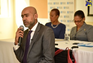 Equality and Inclusion Consultant, United Kingdom (UK), Haqeeq Bostan (foreground), addresses an Inclusion and Diversity Summit at the University of Technology (UTech) in St. Andrew on Wednesday (November 29). Also pictured in the background (from left), are State Minister for Finance and the Public Service, Hon. Fayval Williams; and Minister of Labour and Social Security, Hon. Shahine Robinson. 