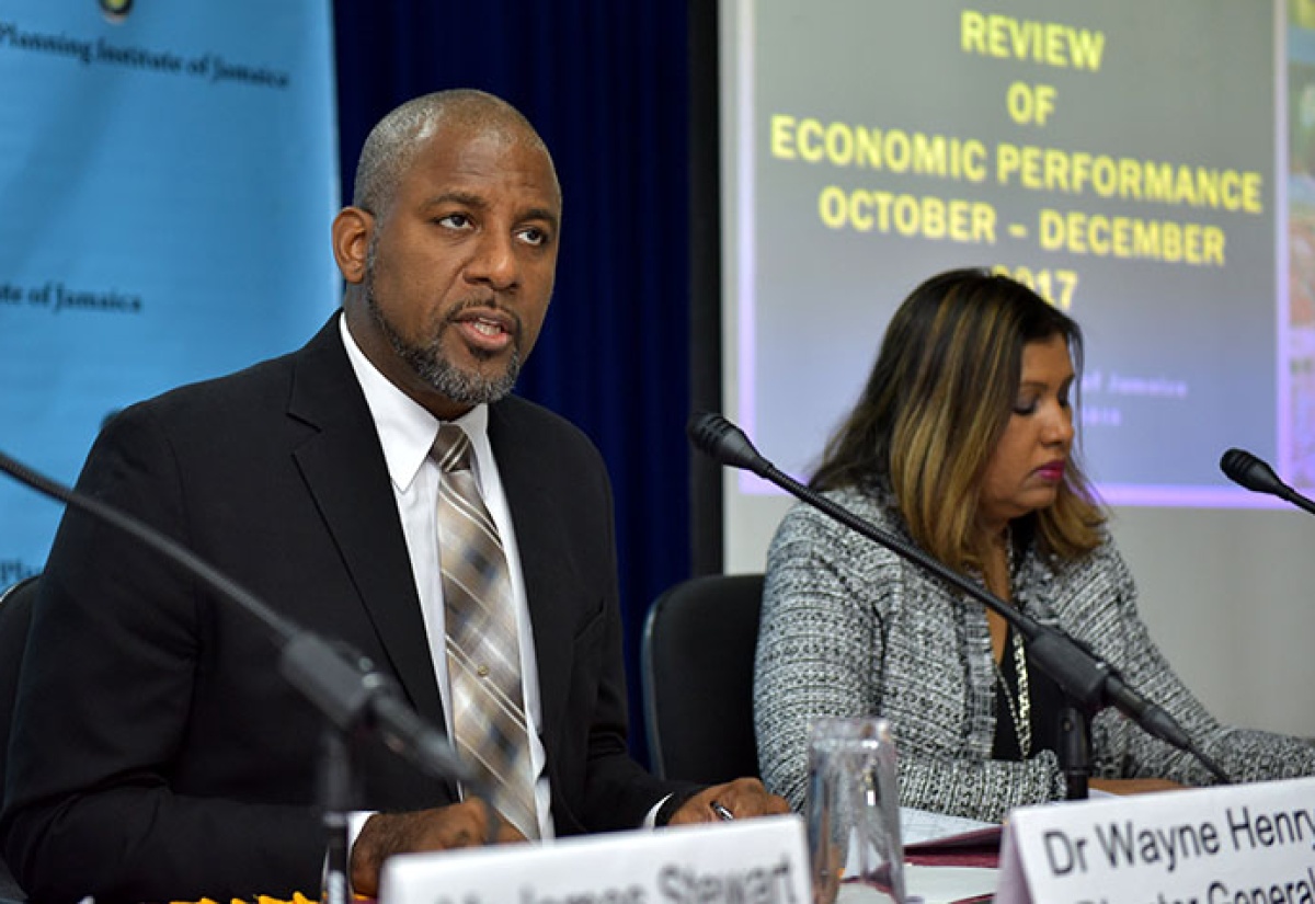 Director General, Planning Institute of Jamaica (PIOJ), Dr. Wayne Henry (left), addressing journalists during Tuesday’s (February 13) quarterly media briefing at the agency’s New Kingston head office. Beside him is Programme Director for the PIOJ’s Vision 2030 Jamaica Secretariat, Elizabeth Emanuel.