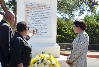 Culture, Gender, Entertainment and Sport Minister, Hon. Olivia Grange (centre); Opposition Leader, the Most Hon. Portia Simpson Miller (right); and Kingston’s Deputy Mayor, Councillor Winston Ennis, view the 1907 Earthquake Monument at Bumper Hall in south west St. Andrew, during a 110th anniversary commemorative ceremony at the site on January 13. The function was organised by the Office of Disaster Preparedness and Emergency Management (ODPEM). Mrs. Simpson Miller is Member of Parliament for the area.