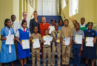 Chief Executive Officer of the Jamaica Information Service (JIS), Mrs. Donna Marie Rowe (3rd left-second row), and Chairman of the JIS Advisory Board, Fae Ellington (4th left),  with students who participated in the 2014 JIS Heritage Competition, and the inaugural Poster Competition, at an awards ceremony, held today (March 6), at King’s House, in St. Andrew.