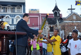 Mayor of Montego Bay and Chairman of the St. James Municipal Corporation, Councillor Homer Davis (left), accepts the Flames of Freedom Emancipation Torch from Javon Mendis of Maroon Town, during the Western Jamaica Leg of the CARICOM Reparations Youth Baton Relay and Rally, which took place in Sam Sharpe Square on  December 27.  