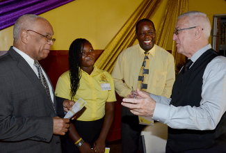 Education Minister, Hon. Rev. Ronald Thwaites (right), shares a light moment with Minister of Transport, Works and Housing, and Member of Parliament for South St. Andrew, Hon. Dr. Omar Davies (left). Occasion was the official opening of the Trench Town Polytechnic College in South St. Andrew on November 17. Others sharing the moment are Tosshell Small; and Director, Region 1, Ministry of Education, Patrice Supria.