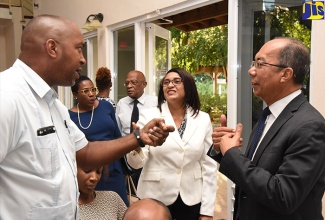 Minister without Portfolio in the Ministry of Economic Growth and Job Creation, Hon. Dr. Horace Chang (right), converses with (from left): South East St. Andrew Member of Parliament, Julian Robinson; and Chief Executive Officer, Real Estate Board, Sandra Watson-Garrick, during the final in a series of public consultations on the proposed Gated Communities and Town House Complexes legislation at St. Andrew High School in Kingston on March 6.  The consultations were hosted by the Real Estate Board/Commission of Strata Corporations.   