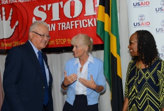 Minister of Justice, Hon. Delroy Chuck (left), is engaged by Country Director of  the United States Agency for International Development (USAID), Denise Herbol (centre), at the launch of ‘Operation Uplift’, a new strategy to fight human trafficking in Jamaica, at the Police Officers’ Club on May 6. At right is Director of the Fi Wi Jamaica Project, Professor Rosalea Hamilton.