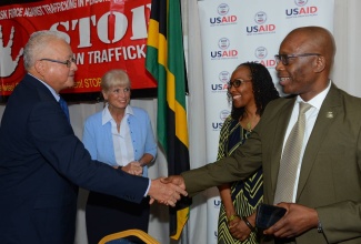 Minister of Justice, Hon. Delroy Chuck, is greeted by Head of the Counter Terrorism and Organised Crime Division of the Jamaica Constabulary Force (JCF), Senior Superintendent of Police (SSP) Clifford Chambers, at the launch of 'Operation Uplift' on Friday (May 6), at the Police Officers’ Club, St. Andrew. Others looking on are Country Director of the United States Agency for International Development (USAID), Denise Herbol (left); and Project Director of the 'FiWi' Jamaica' Project, Professor Rosalea Hamilton. 