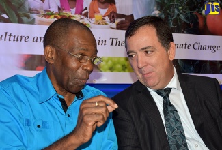 Minister without Portfolio in the Industry, Commerce, Agriculture and Fisheries Ministry, Hon. J.C. Hutchinson (left), in discussion with Canadian High Commissioner to Jamaica, His Excellency Sylvain Fabi, on the final of a two-day Climate-Smart Agriculture symposium, at The Jamaica Pegasus hotel in New Kingston, on September 14.