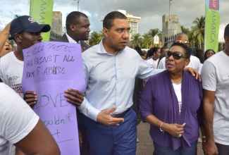 Prime Minister, the Most Hon. Andrew (second right), converses with Culture, Gender, Entertainment and Sport Minister, Hon. Olivia Grange, while participating in an advocacy march in New Kingston, on Wednesday, March 8, which was commemorated as International Women’s Day under the theme: ‘Unite to End Gender-based Violence’.