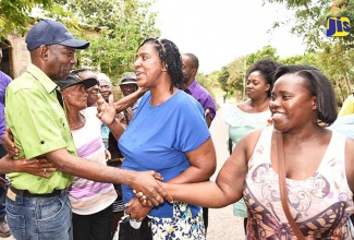 Minister without Portfolio in the Ministry of Industry, Commerce, Agriculture and Fisheries, Hon. J.C. Hutchinson (left), is greeted by residents of Alvie, Manchester (from second left) Yvonne Kennedy, Angella Gordon-Cormier and Vinceleta Gordon. This was after the official opening of the newly paved Alvie farm road in Manchester on April 13.