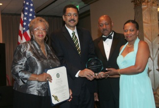 Jamaica’s Ambassador to the United States, His Excellency Professor Stephen Vasciannie (second left); presents the Jamaica Association of Maryland Distinguished Award to Dr.  Hyacinth Dustan-Hunter; at the Association’s Grand Gala held in commemoration of the country’s 51st year of Independence at the Martin’s West Conference Hall in Baltimore on August 3.  Sharing in the occasion are Delegate Shirley Nathan-Pullian  (left); and President of the Association, Rick Nugent. 