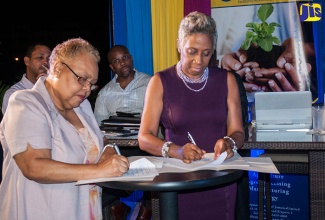 Chief Executive Officer (CEO) of the Jamaica Business Development Corporation (JBDC) Valerie Veira (left), and Manager of First Angels Jamaica, Sandra Glasgow, sign a Memorandum of Understanding (MOU) to provide business support to micro, small and medium-sized enterprises (MSMEs) at the Courtyard Marriott Hotel in New Kingston, recently.