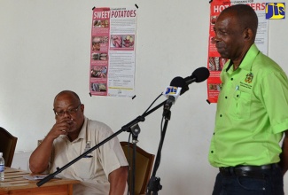 Minister without Portfolio in the Ministry of Industry, Commerce and Agriculture, Hon. J.C. Hutchinson (right), addresses members of the Seville Benevolent Society Production and Marketing Organization (PMO) in St. Ann on October 21. Listening keenly is the Agricultural Parish Manager for RADA, St. Ann, Melvin Aries.