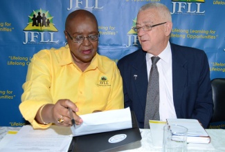 Education Minister, Hon. Rev. Ronald Thwaites (right) and Chairman of the JFLL, Audrey Hinchcliffe, peruse a document at the launch of the Jamaica Foundation for Lifelong Learning’s (JFLL) “Renaissance” initiative today (June 10),  at the institution’s Camp Road headquarters in Kingston. 
