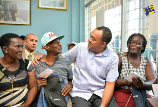 Health Minister, Dr. the Hon. Christopher Tufton (2nd right), shares a light moment with Clarendon resident, Henry Osborne (2nd left), following Monday’s (December 19) launch of the Ministry’s Public Sector Pharmacy Partner Programme at Health First Pharmacy in May Pen. The initiative is being implemented as a pilot in the parish over the next three months. Others (from left) are residents – Lillian Davis and Janett Davis. In the background is May Pen Mayor, Councillor Winston Maragh.