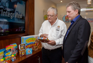 Industry, Commerce, Agriculture and Fisheries Minister, Hon. Karl Samuda (left), and Chief Executive Officer of Rainforest Seafoods, Brian Jardim, peruse a package of fish nuggets during a tour of the entity’s plant on Slipe Road in Kingston, on Friday, May 6. 