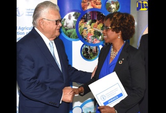 Minister of Industry, Commerce, Agriculture and Fisheries, Hon. Karl Samuda (left), engages with the Food and Agriculture Organization of the United Nations (FAO) Representative for Jamaica, The Bahamas and Belize, Dr. Gillian Smith, at the launch of the 35th Session of the FAO Regional Conference for Latin America and the Caribbean at the Ministry’s New Kingston office on February 13.