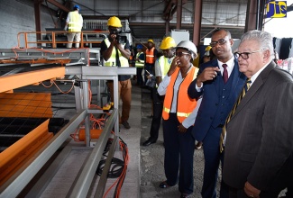 Industry, Commerce, Agriculture and Fisheries Minister, Hon. Karl Samuda (right), is briefed on the operations of ARC Manufacturing Limited’s new $200-million fabric mesh equipment by Managing Director, Norman Horne (second right), during Tuesday’s (November 21) commissioning ceremony. ARC Manufacturing is located on Bell Road in Kingston. At third right is Member of Parliament for South West St. Andrew, where ARC Manufacturing’s Bell Road-based complex is located, Dr. Angela Brown Burke.