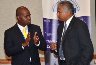 Director General of the Jamaica Civil Aviation Authority (JCAA), Nari Williams-Singh (right), listens keenly to President of the Jamaica Air Traffic Controllers Association (JATCA), Kurt Solomon. Occasion was the opening of the 26th regional meeting of the International Federation of Air Traffic Controllers Association (IFATCA), at the Holiday Inn Resort in Montego Bay on Thursday (October 15). 