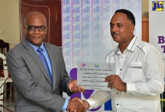 Managing Director of the Jamaica Social Investment Fund (JSIF), Omar Sweeny (right), presents Member of Parliament for North East St. Catherine, Leslie Campbell, with a plaque marking the completion of the $30-million Bottom Bonnet Road Project in the parish. Occasion was the recent handover ceremony for the road project in North East St. Catherine.