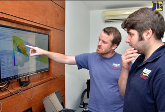 EGS Survey Hydrographical Surveyor, Liam Flynn (left), and colleague, Matthew Lock, examine an image of the area of Kingston Harbour being surveyed. 

