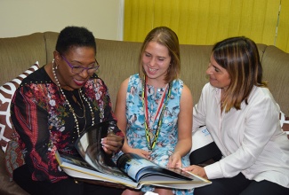 Minister of Culture, Gender, Entertainment and Sport, Honourable Olivia Grange, shows Lucy Meyer, Spokesperson for Special Olympics and the U.S Fund for UNICEF historic sites in Jamaica from the book, Jamaica: Heritage in Pictures by the Jamaica National Heritage Trust. Looking on is her mother Lucy Meyer. Lucy, is visiting Jamaica to help generate visibility and promote programmes that will benefit children with disabilities. She paid a courtesy call on the Minister on September 22, 2016 at her office in Kingston.